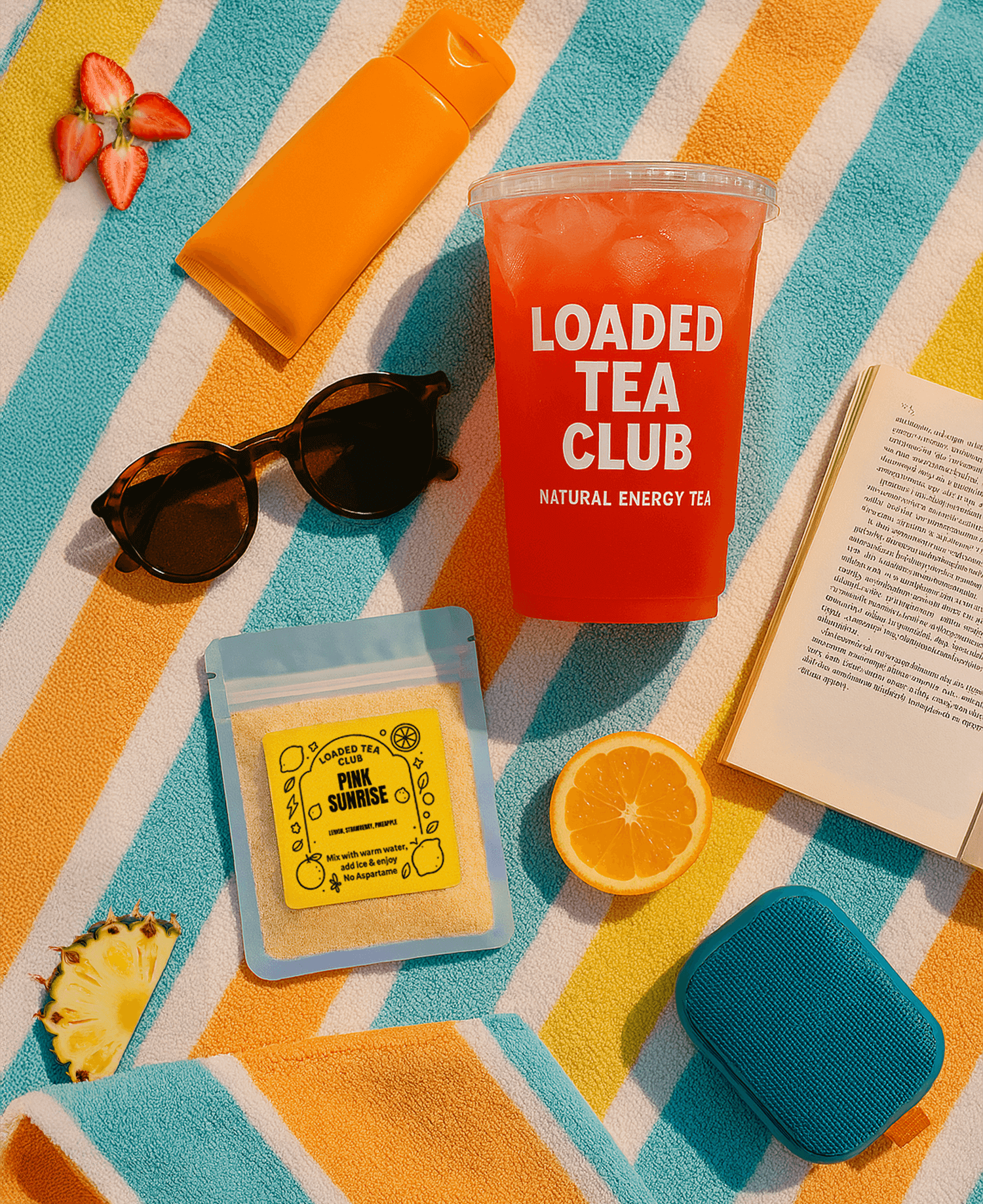 Loaded tea in a cup with sunglasses, a beach towel, and tea packets, perfect for summer refreshment.
